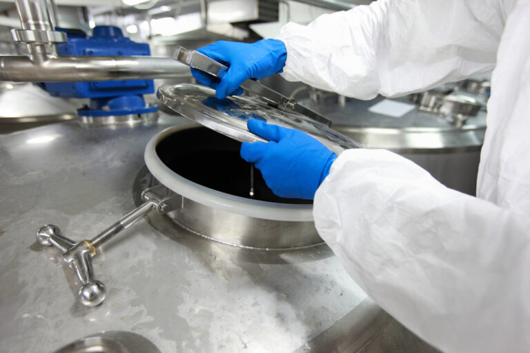 Technicians sampling catalyst from industrial reactor vessel